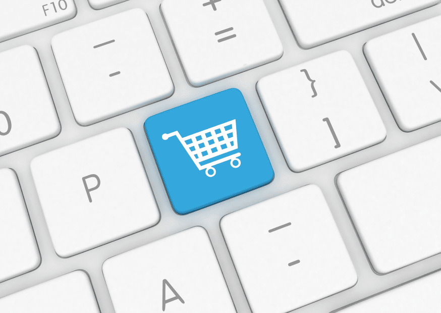 Instant e-commerce concept with a vivid blue shopping cart icon on a keyboard key.